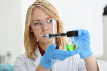 Technician hold in arms in protective gloves sample bottle with poison fluid portrait. Medical worker in uniform use reagent tube for virus infection exam or biological toxic reaction drug creation