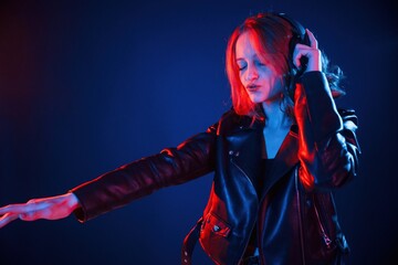 With headphones. Cool young woman portrait in neon colors