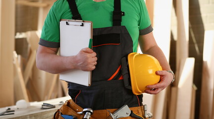 Handyman with hands on waist and tool belt with construction tools against wood background. DIY...