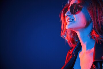 Side view, in eyewear. Cool young woman portrait in neon colors
