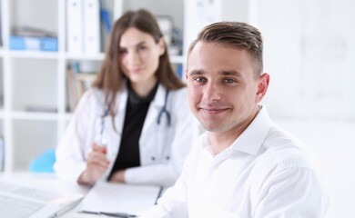 Satisfied happy handsome smiling male patient with doctor at her office. High level and quality medical service therapeutist consultation work and career physical healthy lifestyle concept