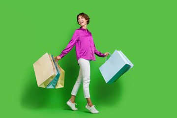Full length photo of lovely cheerful girl wearing purple clothes carrying packages looking empty...
