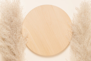 Wooden empty product podium with pampas grass on beige background, top view. Aesthetic minimal showcase for eco, natural product presentation