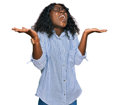 Beautiful african young woman wearing casual clothes and glasses celebrating mad and crazy for success with arms raised and closed eyes screaming excited. winner concept