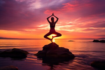a woman doing some yoga poses near the ocean after sunset