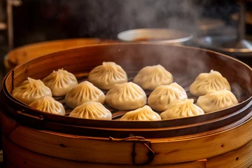 Gordijnen Delicious Xiao Long Bao dumplings served in a bamboo steamer at a popular street food market in Shanghai, China © aicandy