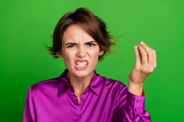 Photo of crazy outraged furious girl dressed stylish purple clothes showing fingers wtf problem trouble isolated on green color background