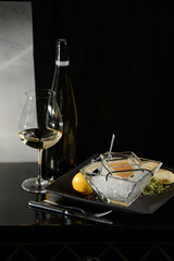 Pike fish caviar, on ice, with croutons, lemon, on a transparent dish, on a dark background