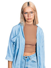 Beautiful young blonde woman wearing glasses depressed and worry for distress, crying angry and afraid. sad expression.