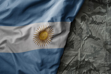 waving flag of argentina on the old khaki texture background. military concept.