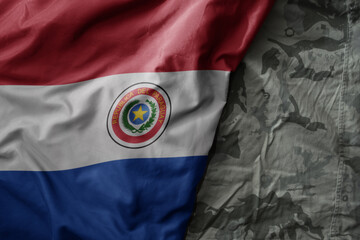 waving flag of paraguay on the old khaki texture background. military concept.