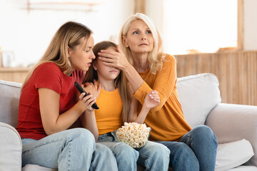 Family watching TV horror movie together at home