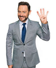 Middle age man wearing business clothes showing and pointing up with fingers number four while smiling confident and happy.