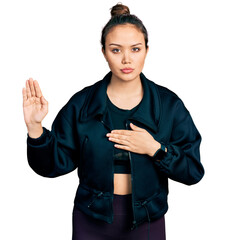 Young hispanic girl wearing sportswear swearing with hand on chest and open palm, making a loyalty...