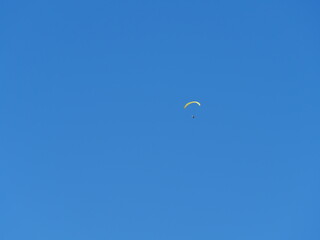 Parapentiste dans une sellette cocon à haute altitude sous un ciel bleu