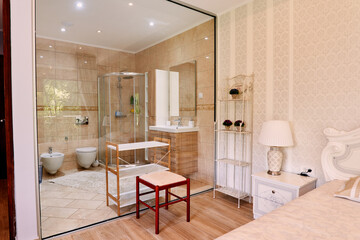 View from the bedroom to the bathroom behind a transparent glass wall