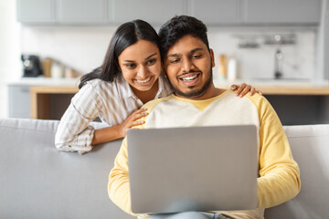 Happy Young Indian Couple Using Laptop Together At Home