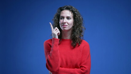 Curly 20s female person having eureka moment. Woman raising finger in the air during epiphany,...