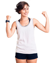 Beautiful young woman with short hair wearing casual sport clothes screaming proud, celebrating...