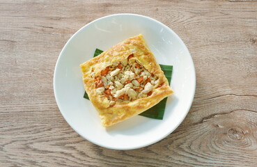 fried mashed pork with tomato and onion stuffed in Thai egg omelets on plate 