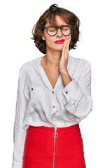 Young hispanic woman wearing business style and glasses touching mouth with hand with painful expression because of toothache or dental illness on teeth. dentist