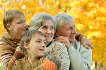 Fototapeta premium Grandparents and grandchildren together in autumn park