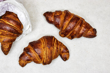three homemade Fresh croissants on gray background