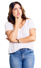 Young beautiful caucasian woman wearing casual white tshirt thinking worried about a question, concerned and nervous with hand on chin