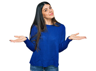 Young hispanic woman wearing casual clothes clueless and confused expression with arms and hands...