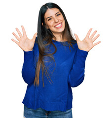 Young hispanic woman wearing casual clothes showing and pointing up with fingers number ten while smiling confident and happy.