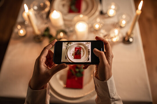 technology, christmas and holidays concept - close up of hands with smartphone photographing table serving