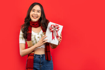 .Happy smiling asian woman holding gift box over red .Happy smiling asian woman holding gift box...
