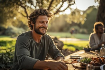 Smiling Man Enjoying a Meal Outdoors at Sunset with Friends

man, smiling, outdoors, sunset, meal, friends, happiness, casual, dining, nature, picnic, summer, evening, joy, relaxation, leisure, park