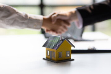 Businessman shaking hands with real estate agent in office after reaching home purchase agreement.