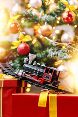 A steam locomotive rides on rails on a Christmas tree.