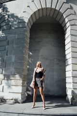 Fototapeta na wymiar Slender blonde on a walk near the stone walls