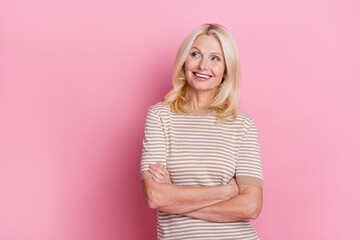 Photo of nice person with blond hairstyle dressed striped t-shirt arms crossed look at sale empty space isolated on pink color background