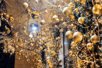 House facade winter decorations with tree branches, bulbs and glow garlands