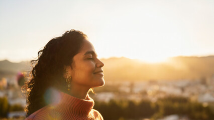 Close-up portrait of African American woman breathing deeply outdoors on a fall day at sunset with blurred background and copy space. Profile view of African American woman breathing deeply