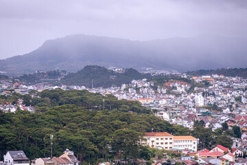 Naklejka premium View on roofs in the city of Dalat. Da Lat and the surrounding area is a popular tourist destination of Asia. City with fogs and mountains