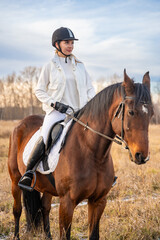 Beautiful blond professional female jockey riding a horse