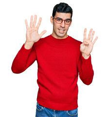 Handsome hispanic man wearing casual clothes and glasses showing and pointing up with fingers number nine while smiling confident and happy.