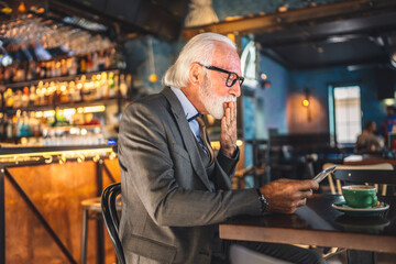 Senior man businessman business owner use digital tablet sit at cafe