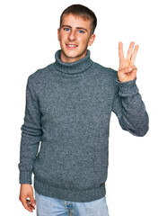 Young blond man wearing casual clothes showing and pointing up with fingers number three while smiling confident and happy.