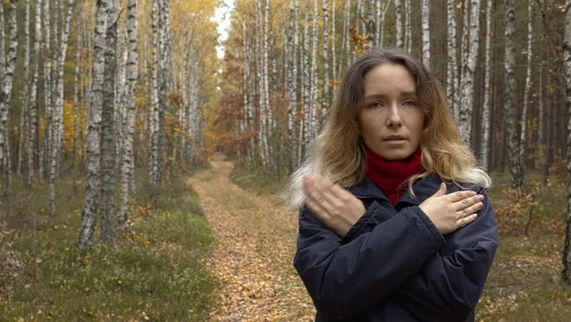 Female tapping her shoulders, crossing hands. Butterfly hug. Forest natural landscape.