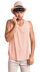 Young hispanic man wearing summer hat touching mouth with hand with painful expression because of toothache or dental illness on teeth. dentist