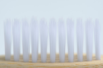 White bristles of wooden toothbrush in closeup.