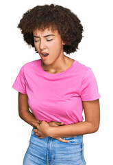 Young hispanic girl wearing casual clothes with hand on stomach because nausea, painful disease feeling unwell. ache concept.