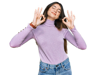 Young beautiful teen girl wearing turtleneck sweater relaxed and smiling with eyes closed doing meditation gesture with fingers. yoga concept.