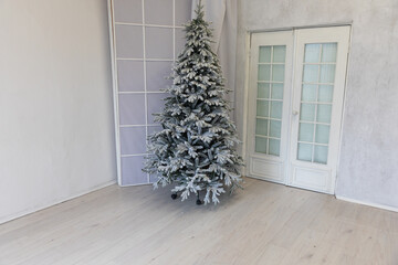Christmas tree for new year with gifts in white interior
